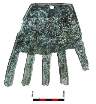 Une pierre gravée, en forme de main, avec du basque écrit dessus.