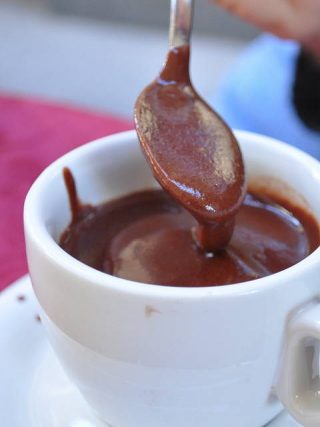 Une tasse de chocolat, lequel coule d'une cuillère