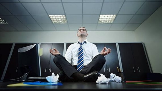 Manager en position Yoga/zen sur son bureau