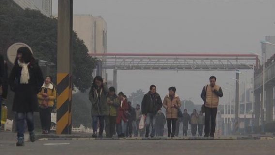 Des ouvriers, hommes et femmes, sortent de leur usine à Shangaï