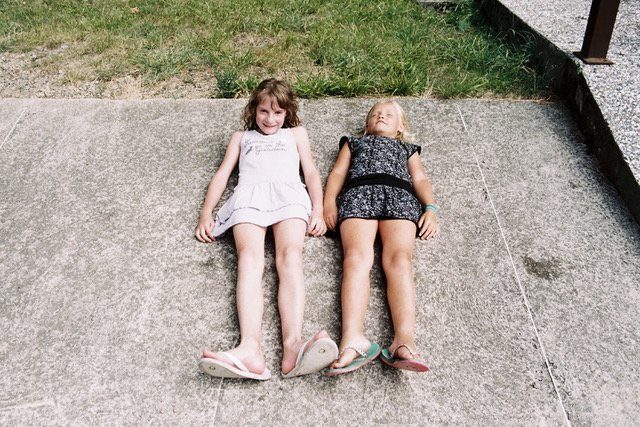 Photo de deux enfants allongés par terre