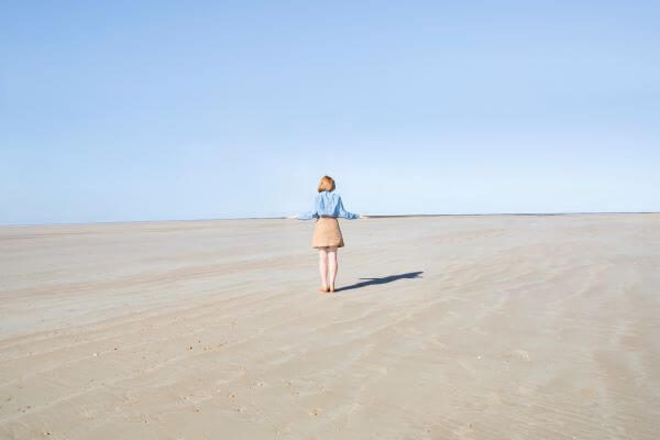 Une jeune femme de dos sur une plage