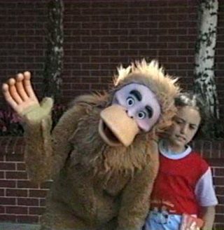 Un homme déguisé en singe et une petite fille