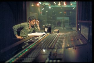 Serge Gainsbourg devant une table de mixage, en studio.