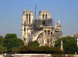 La cathédrale Notre-Dame de Paris avec une grue à l'arrière-plan et des échafaudages sur le toit.