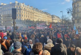 Une foule dans la rue, à Paris, et au milieu une pancarte, "en lutte !".
